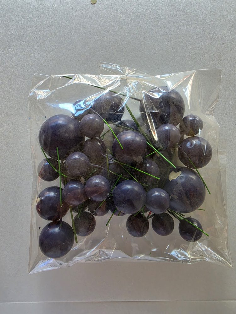 Bolsa con esferas moradas oscuras de varios tamanos montadas