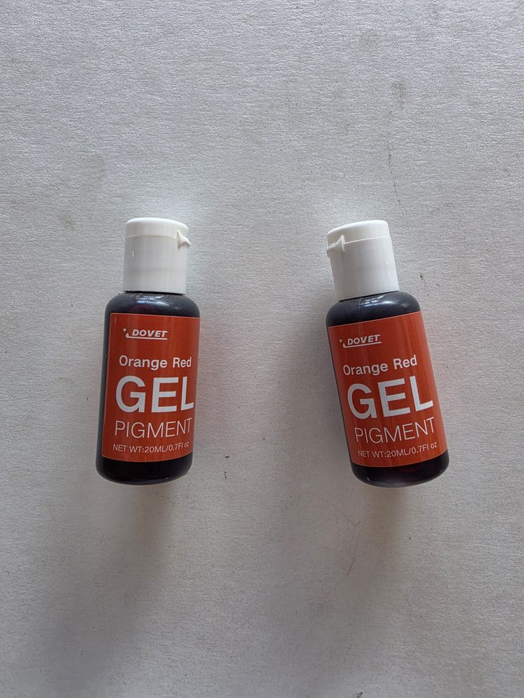 Dos frascos de pigmento en gel color rojo anaranjado, etiqueta