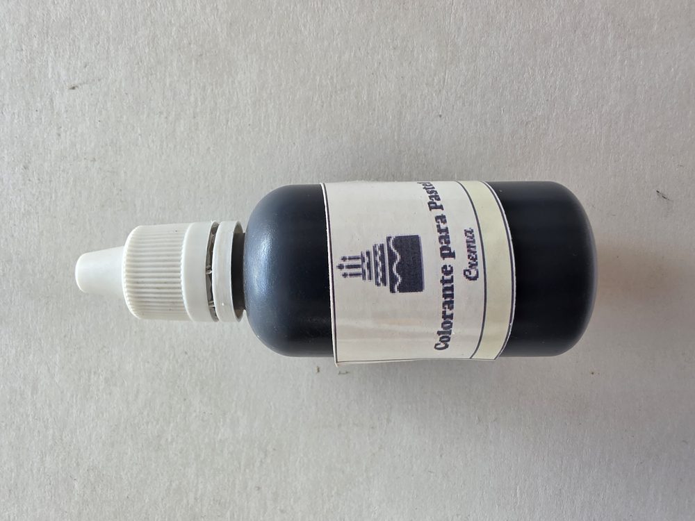 Frasco gotero de colorante para pastel con contenido azul oscuro casi