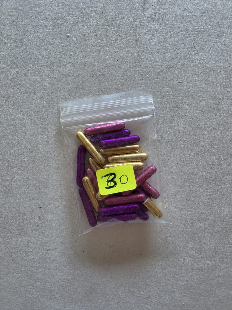 Bolsita plastica pequeña con barritas metalizadas moradas, rosadas