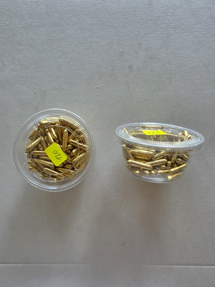 Grageas alargadas tipo barritas metalizadas doradas en dos vasitos
