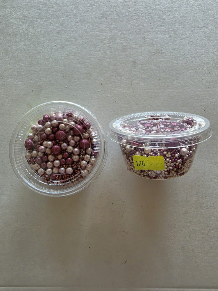 Mezcla de perlas y grageas rosadas, fucsia y blanco perlado en dos
