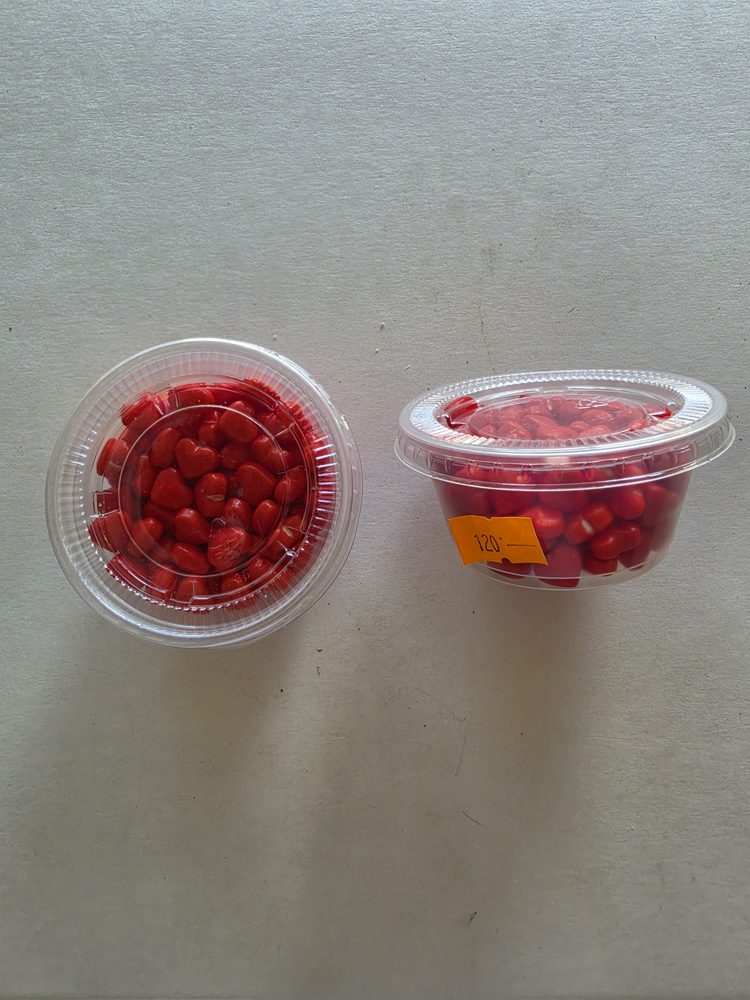 Corazones de azúcar rojos en dos vasitos plásticos transparentes