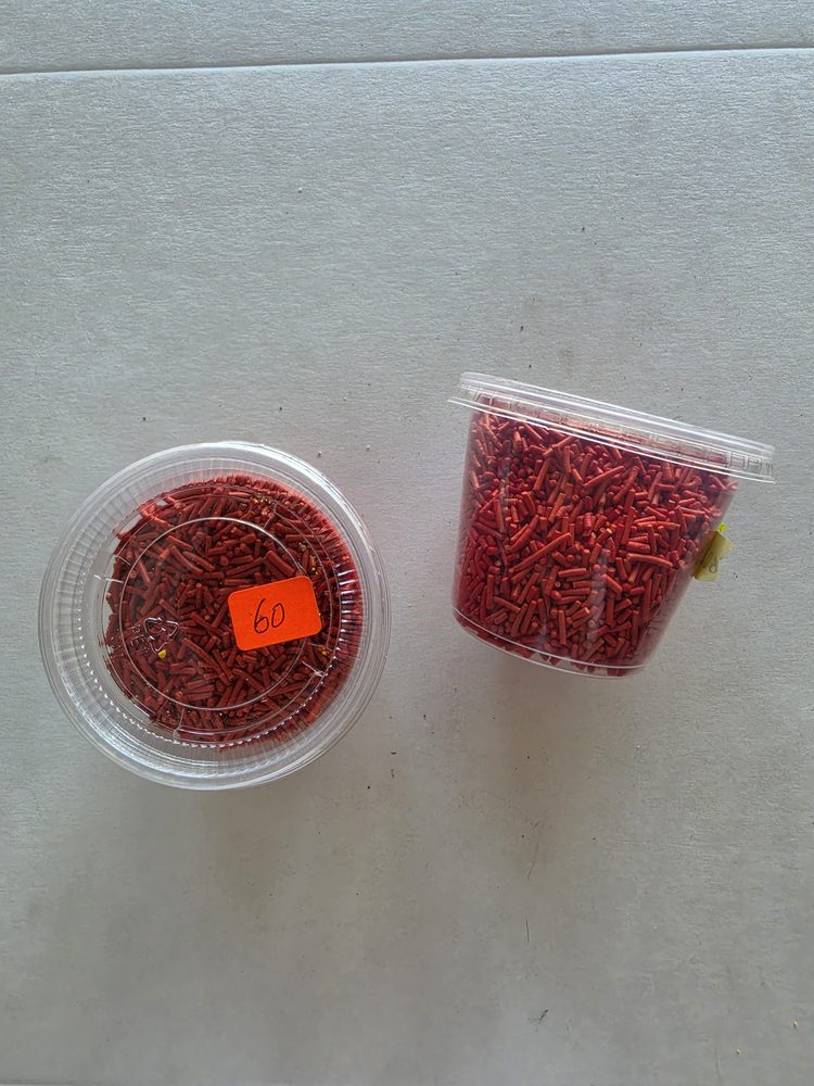 Chispas o granillo comestible rojo en vaso plástico transparente
