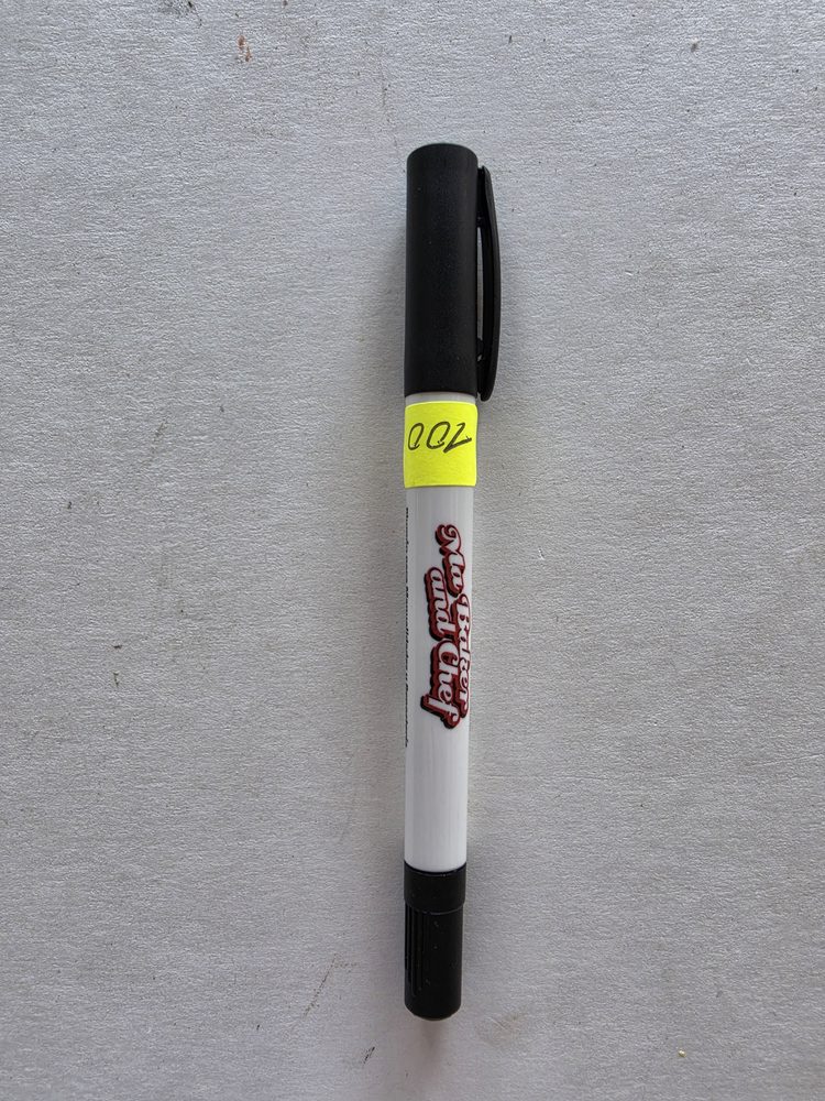 Marcador comestible de tinta negra, cuerpo blanco con tapa y punta