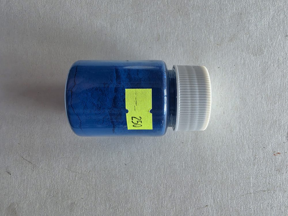 Frasco plástico con polvo perlado azul, tapa blanca de rosca