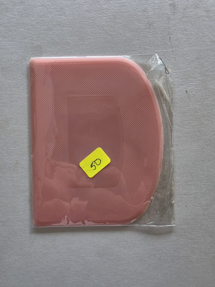 Raspador o espátula de plástico rosado con superficie texturizada