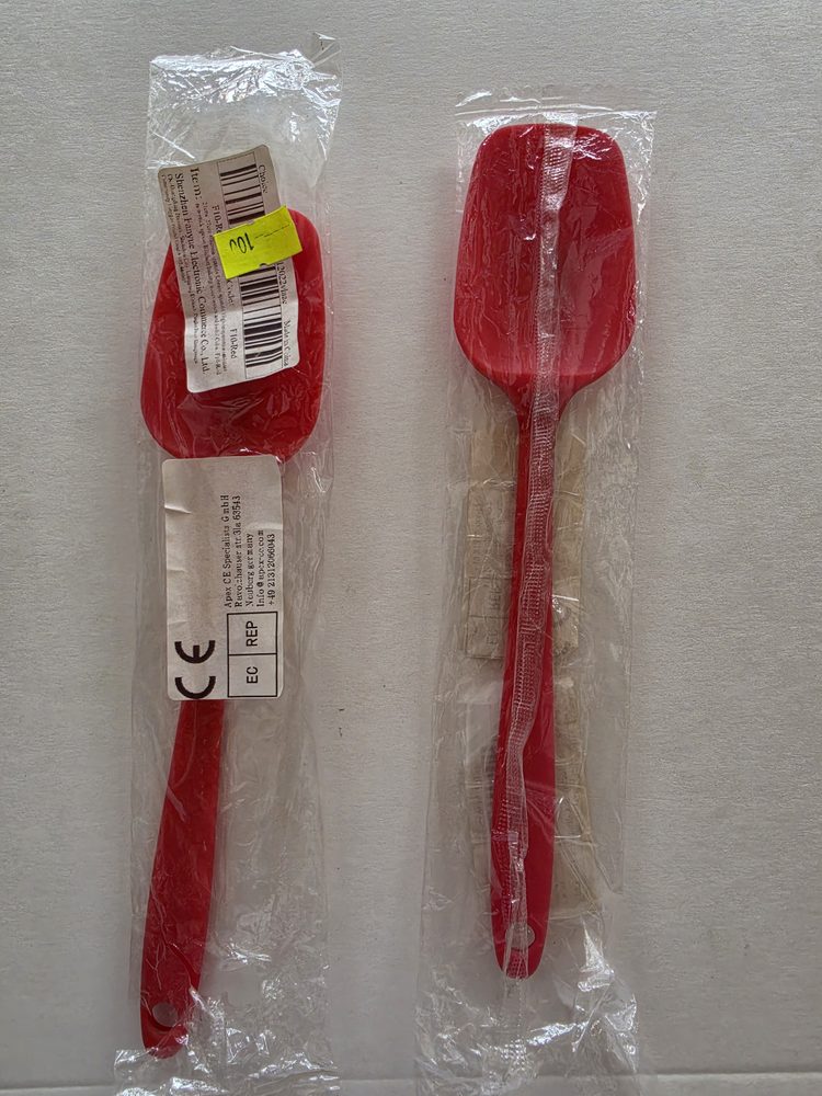 Dos espátulas miserables de silicón rojo con mango del mismo color