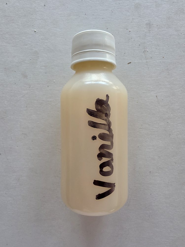 Esencia sabor vainilla, liquido color crema claro en frasco plástico
