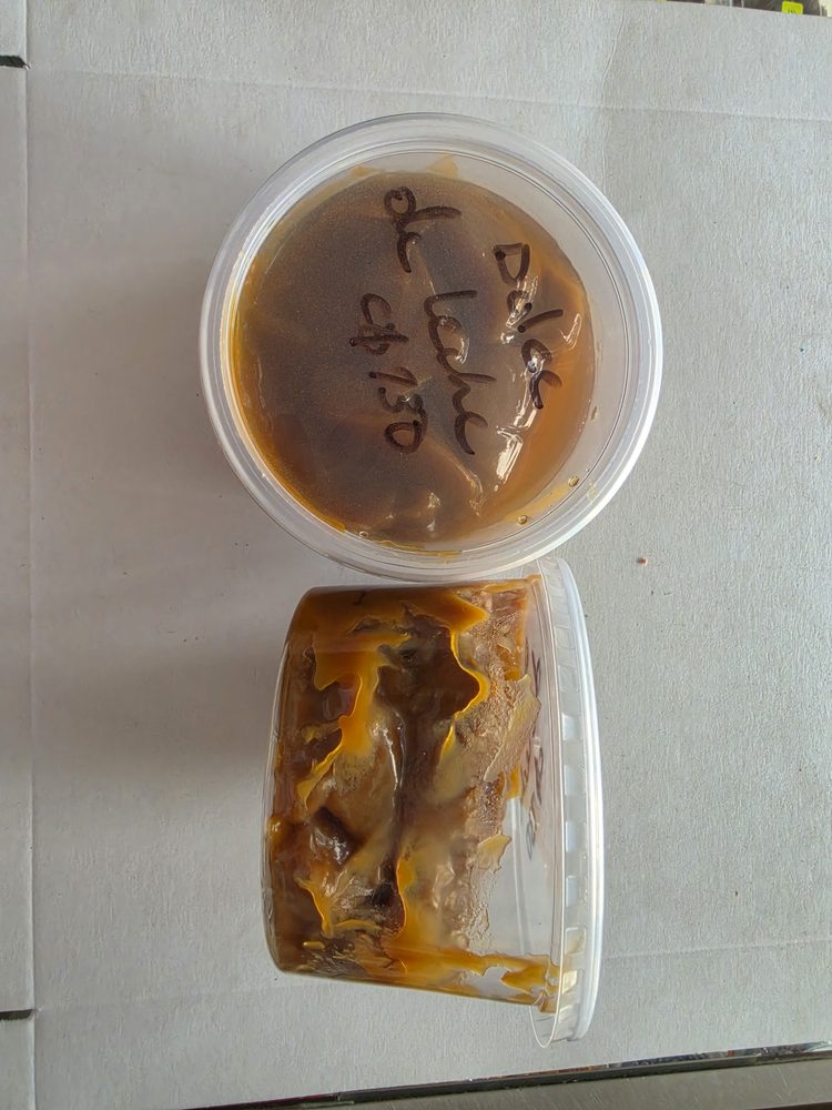 Dos envases plásticos transparentes con dulce de leche color café