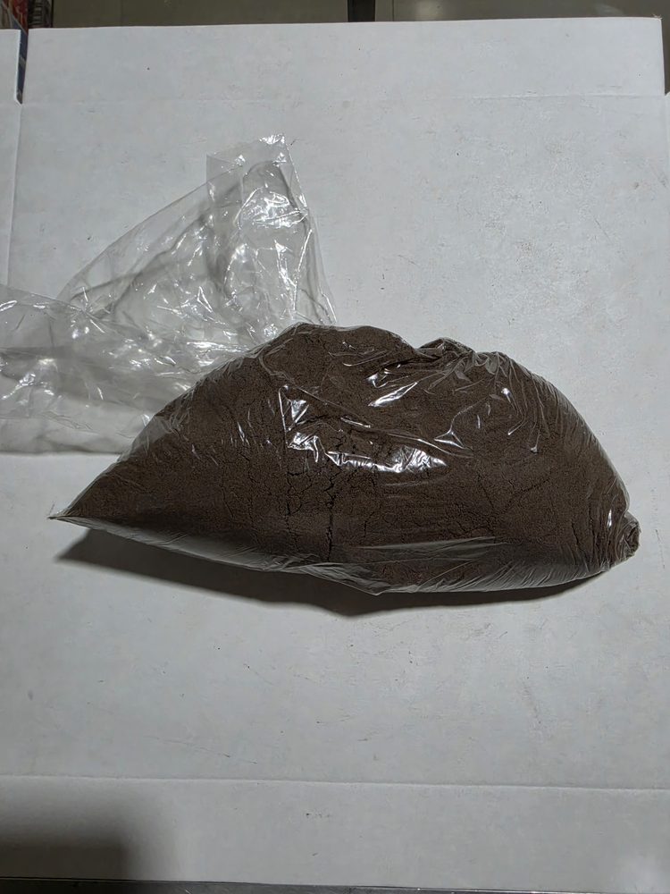 Bolsa plastica transparente con polvo café oscuro a granel, aspecto
