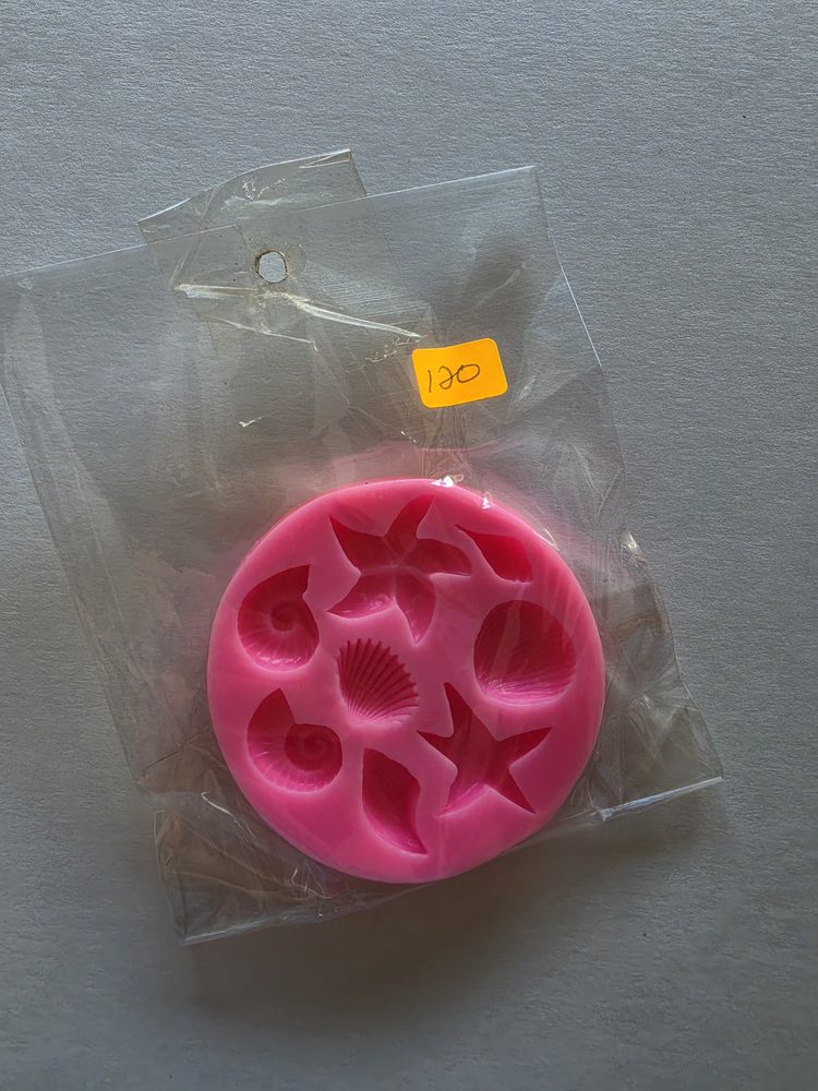 Molde de silicón rosado redondo con conchas, caracoles y estrellas