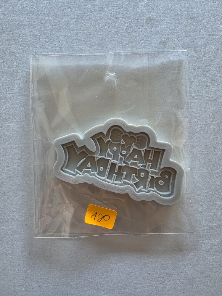 Molde de silicón blanco con la frase HAPPY BIRTHDAY y un moño