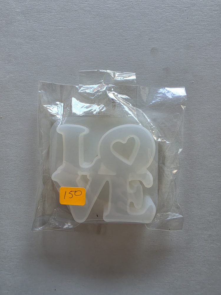 Molde de silicón blanco translúcido con la palabra LOVE y un corazón