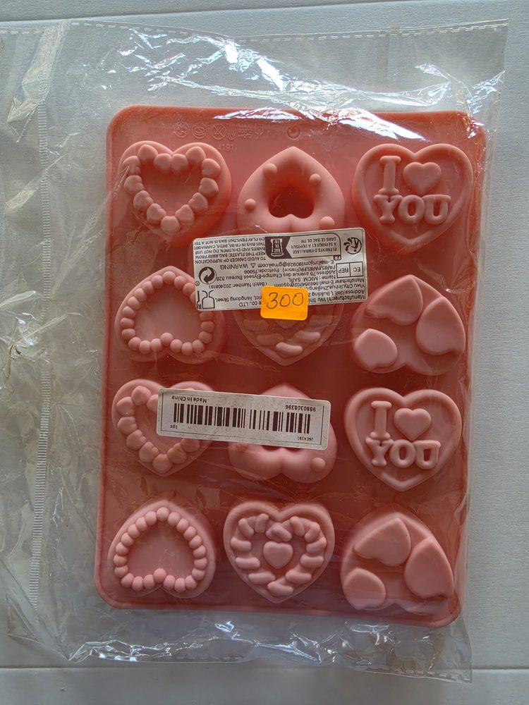 Molde de silicón rosado rectangular con 12 cavidades de corazones