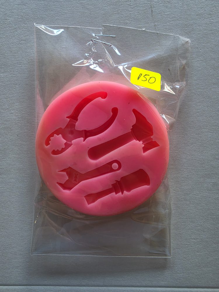 Molde de silicón rosado redondo con figuras de herramientas