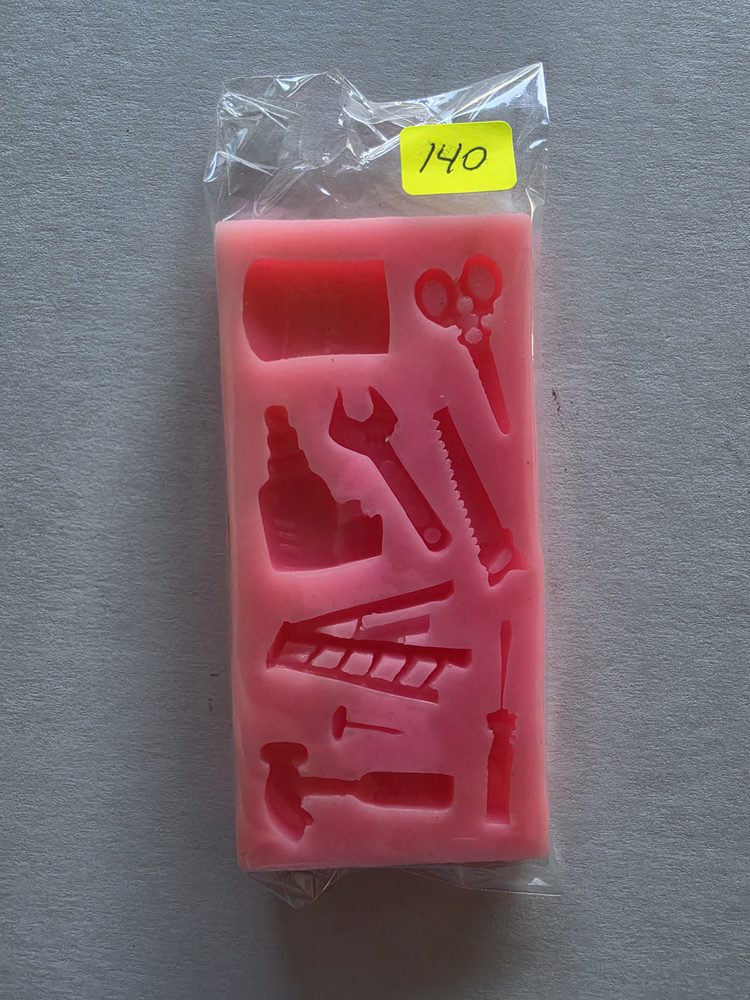 Molde de silicón rosado rectangular con figuras de herramientas