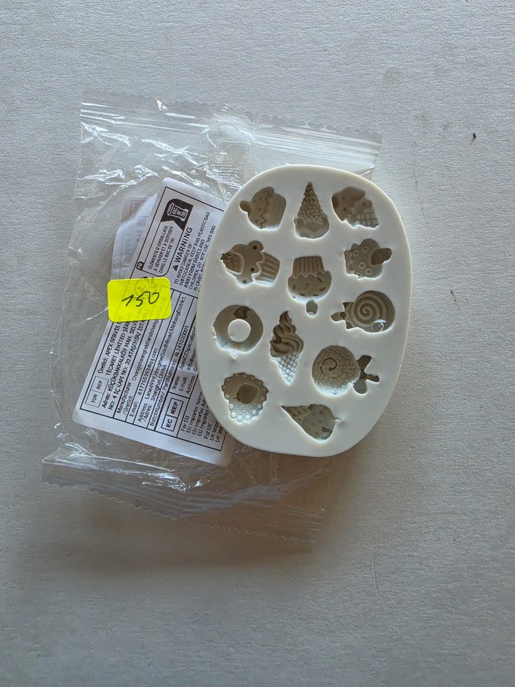 Molde de silicón blanco ovalado con 13 figuras pequeñas de postres