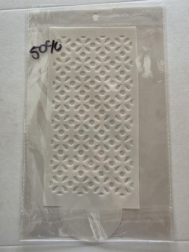 Esténcil rectangular de plástico blanco con patrón calado de flores