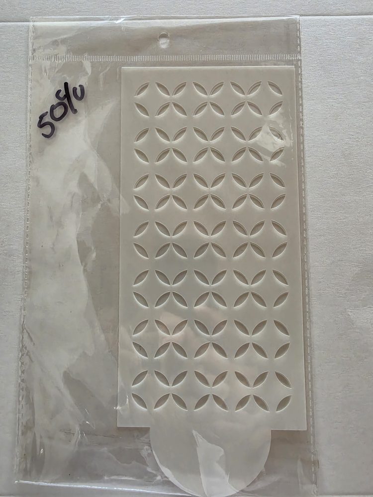 Esténcil rectangular de plástico blanco con patrón calado geométrico