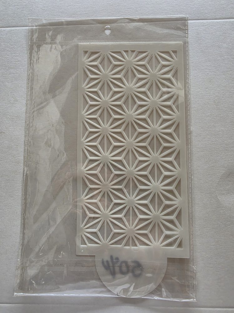 Esténcil de plástico blanco rectangular con patrón geométrico