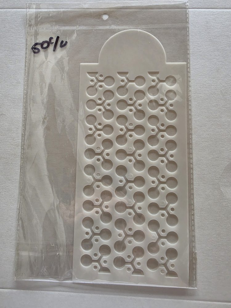 Esténcil de plástico blanco rectangular con patrón calado de círculos