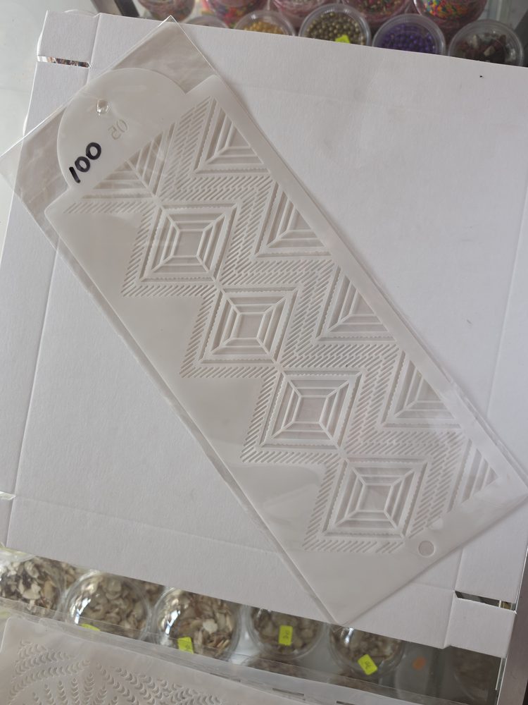 Plantilla stencil alargada de plástico blanco con patrón calado